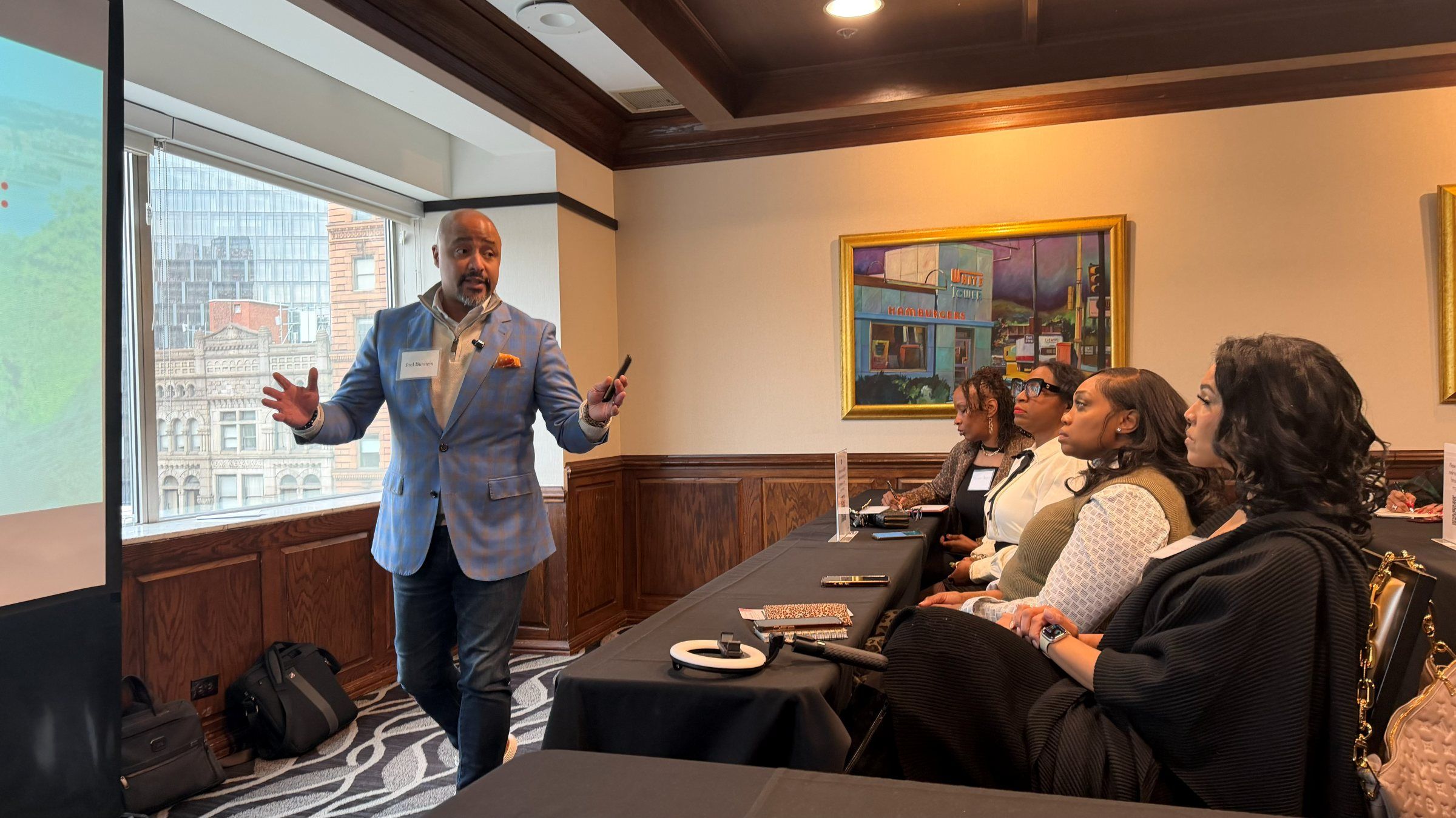 A BEAM instructor leading a working session for a table of business owners