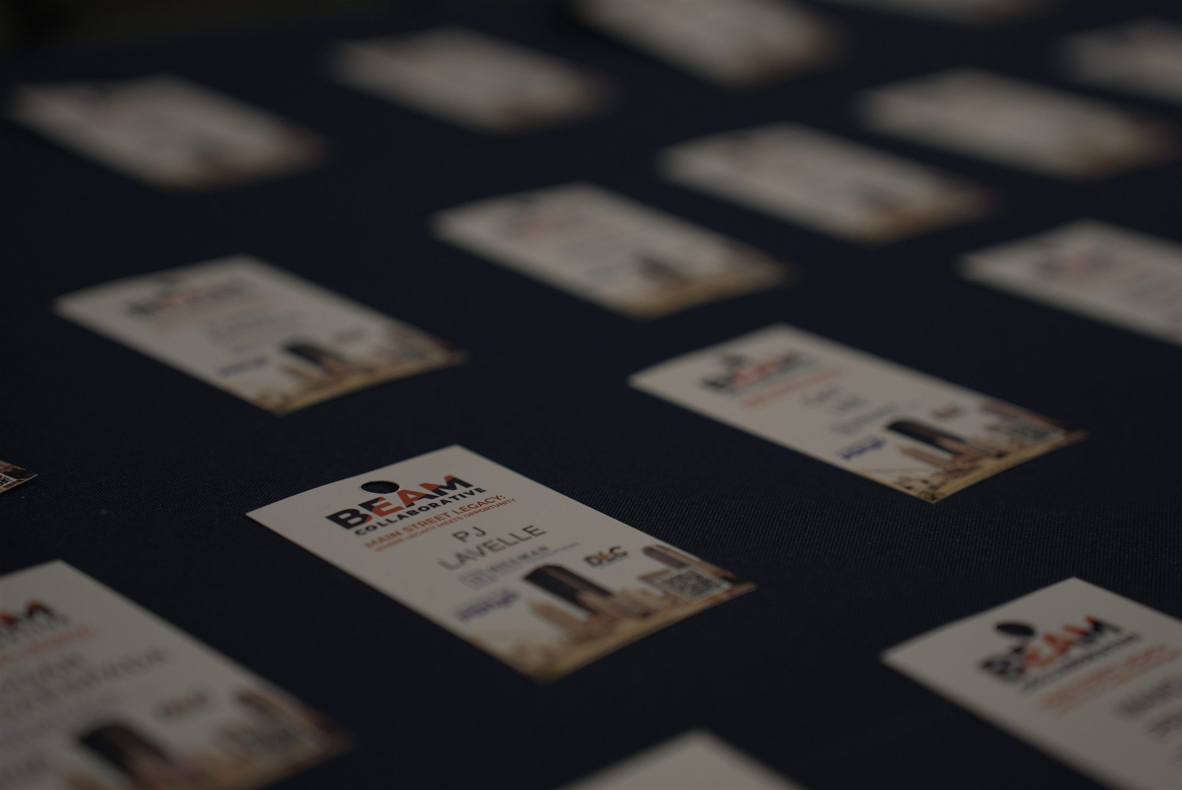 Rows of BEAM Collaborative name badges laid out before an event